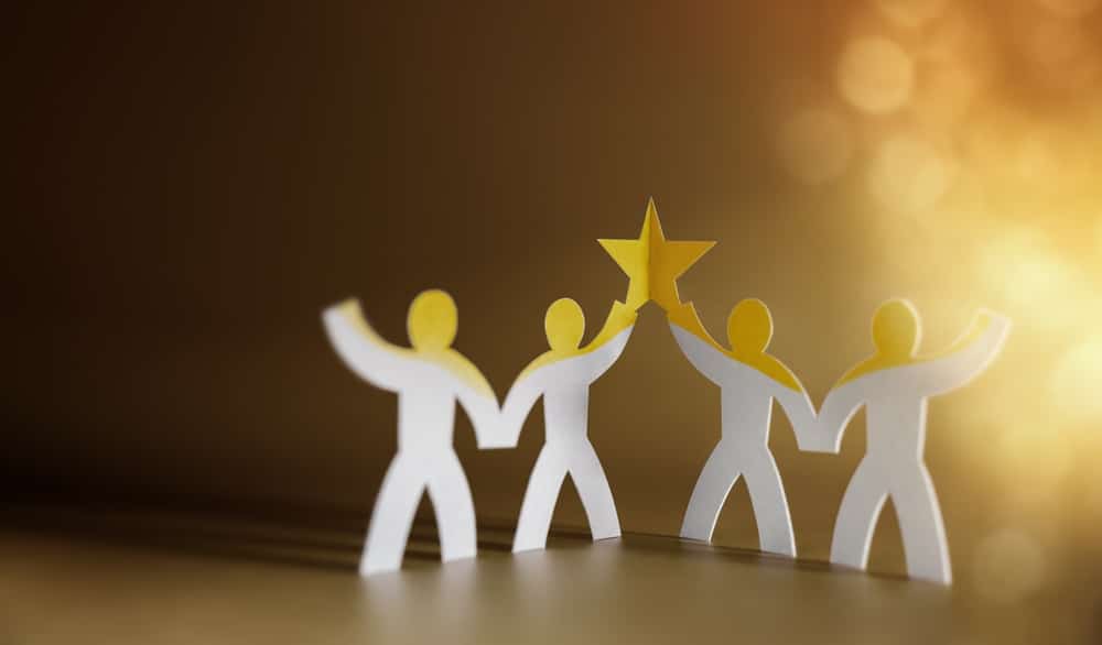 Four paper cutouts holding up a yellow star
