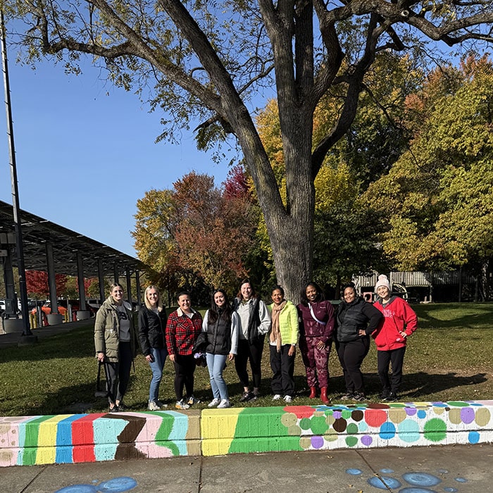 The Human Resources team standing next to the flower boxes they painted at Fuller Park