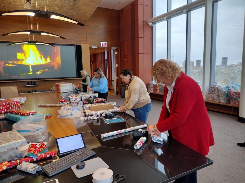 People wrapping gifts in the gift-wrapping room at the Ross Holiday Party