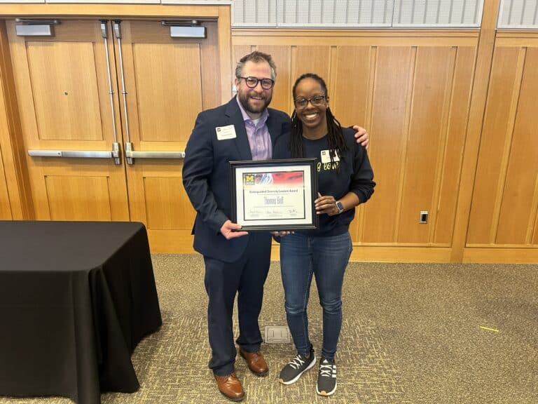 Thomn Bell and Justine Shelton hold an award at the Distinguished Diversity Leaders Award ceremony.